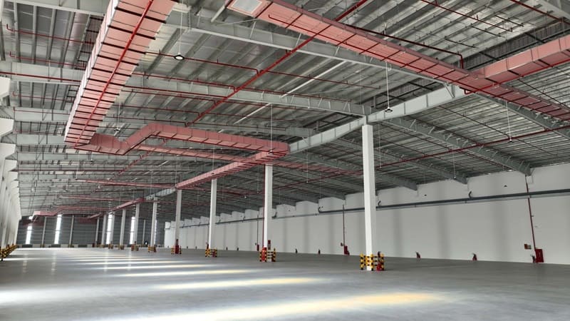 A large warehouse with red beams Description automatically generated